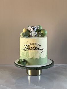 a birthday cake decorated with green and white frosting