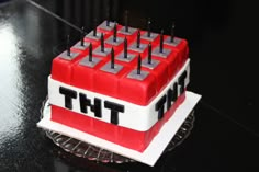 a red and white cake with the word tht on it sitting on a table