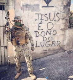 a soldier standing in front of a wall with graffiti on it