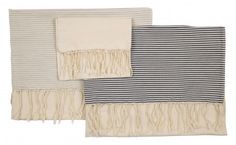 three towels with fringes on them sitting next to each other