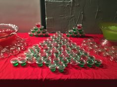 a table topped with lots of cups and bowls on top of a red table cloth