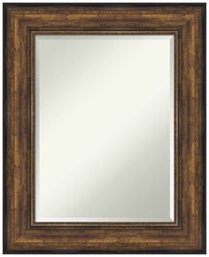 a brown framed mirror on a white wall