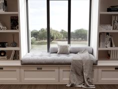 a window seat with pillows on it in front of a bookshelf