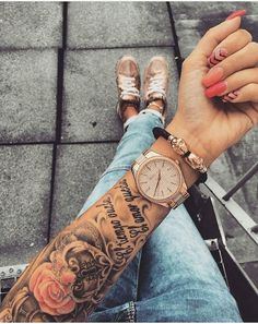 a woman's arm with a rose tattooed on it and a watch in her hand