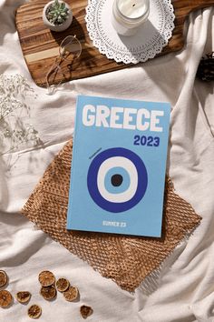 a book sitting on top of a bed next to a cup and plate with food