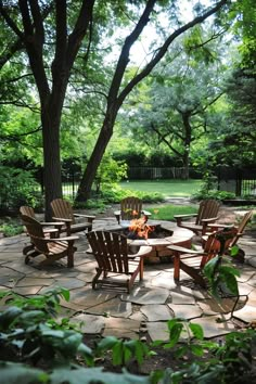 an outdoor fire pit surrounded by chairs and trees