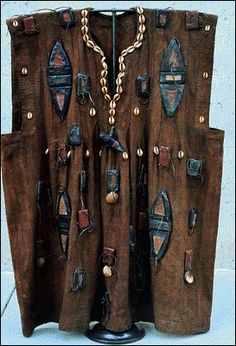 a piece of art made out of old pieces of clothing with chains and beads on them