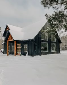 a black house with snow on the ground