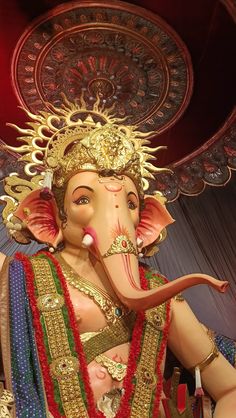 an elephant statue is adorned with gold and red beads