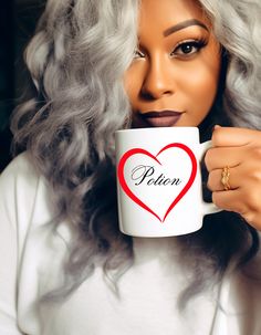 a woman with grey hair holding a white coffee mug