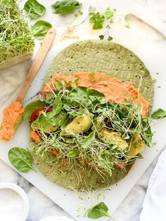 an open face sandwich with carrots, lettuce and avocado on it