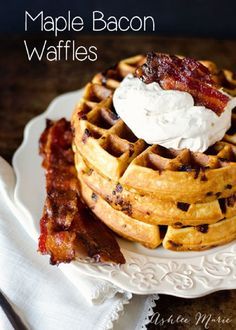 bacon waffles on a white plate topped with whipped cream