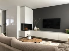 a living room filled with furniture and a flat screen tv mounted on a wall above a fire place