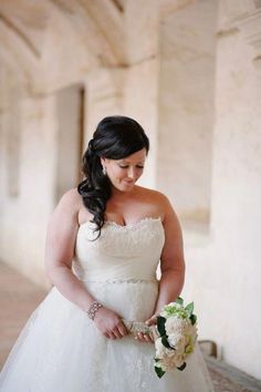 a woman in a wedding dress holding a bouquet