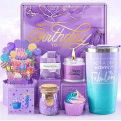 a purple birthday gift box with cupcakes, candles and other items in it