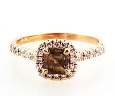 an engagement ring with a brown diamond surrounded by white diamonds