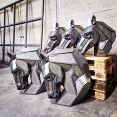 several metal horse heads sitting on top of wooden pallets