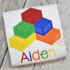 a close up of a piece of cloth on a wooden surface with the word,'alden'written in lego blocks