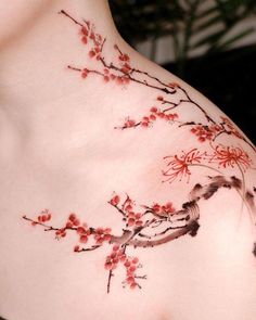 a woman's chest with red flowers and birds painted on the back of it