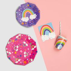 two paper plates with rainbows and clouds on them, one has a drink in it