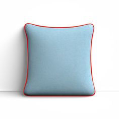 a blue and red pillow sitting on top of a white wall