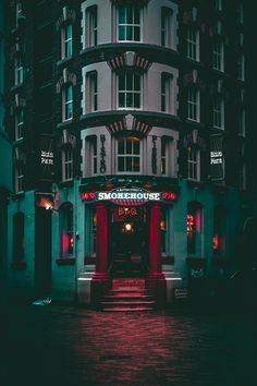 a tall building sitting next to a red fire hydrant in front of it's entrance