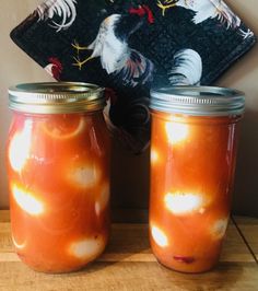 two jars filled with food sitting on top of a wooden table