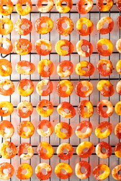 doughnuts are being cooked on a wire rack