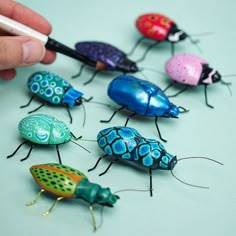 a person is drawing on some colorful bugs