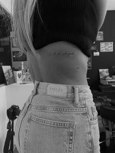 a woman's lower back tattoo with the word love in cursive writing