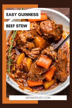 beef stew in a white bowl with carrots and rosemary garnish on the side