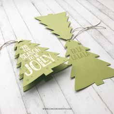 two wooden christmas trees with the words tis season to be jolly hanging from twine