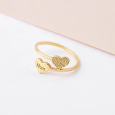 a heart shaped ring with the word mom written on it and a fingerprint in the middle