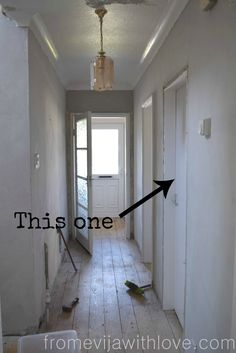 an empty hallway with the door open and one arrow pointing to the other way in front of it