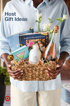 a man is holding a basket full of books and wine bottles with the caption, host gift ideas