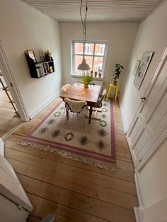 a dining room with a table and chairs on the hardwood floor next to a window