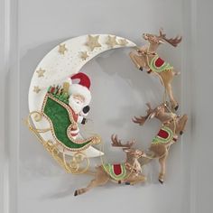 santa claus riding on his sleigh with reindeers in front of the moon