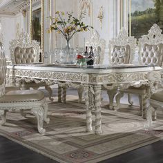 an ornate dining room table and chairs in white