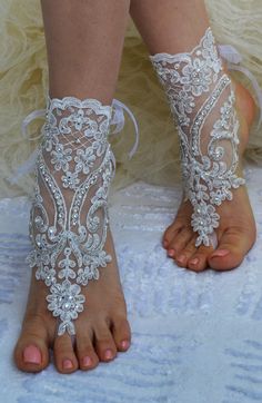 barefoot bride's feet with white lace and beaded garters on them