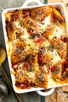 a casserole dish with ham, cheese and bread in it on a table