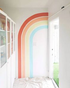 a bedroom with a rainbow painted on the wall