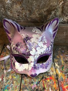 "Original hand-painted Venetian mask embellished with decoration with stucco and non-toxic acrylic colors and glitter. -Material/Resin Made in Italy hypoallergenic and non-toxic. -Dimensions/18x18 Unisex -History of the mask / a double legend intertwines the fate of this mask of the appearance of a cat. From ancient texts it would be a \"Sacred\" animal for the city of Venice because it would have saved it from the terrible plague of the 16th century managing to defeat the mice that carried the Cat Masquerade Mask, Painted Masks, Jester Mask, Mask Carnival, Joker Mask, Mask Cat, Venice Mask, Ceramic Mask, Carnival Mask