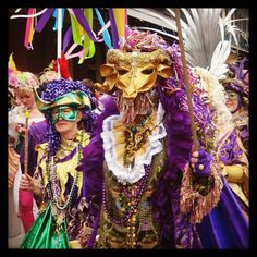 two people dressed in costumes and masks at a carnival