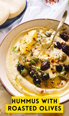 hummus with roasted olives in a bowl and pita bread on the side