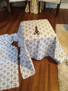 a pair of scissors sitting on top of a table covered in a blue and white cloth