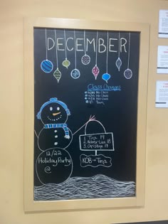 a chalk board with a drawing of a snowman next to a sign that says december