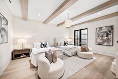 a large bedroom with two beds and white furniture in it's centerpieces