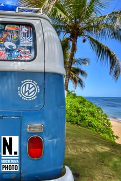 an old vw bus parked on the side of a road near the beach with palm trees