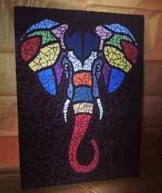 an elephant made out of stained glass sitting on top of a table