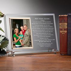 a couple's photo and two books on a table next to a vase with flowers